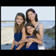 Smiling aunt and her neices having their portrait taken on the rocks of Moody Beach Wells Maine