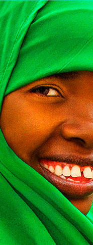 woman in bright green head wrap and brilliant smile at kennebunk farmers market maine