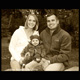 Sepia tone photograph of a young mother and father and their new daughter out enjoying an autumn day